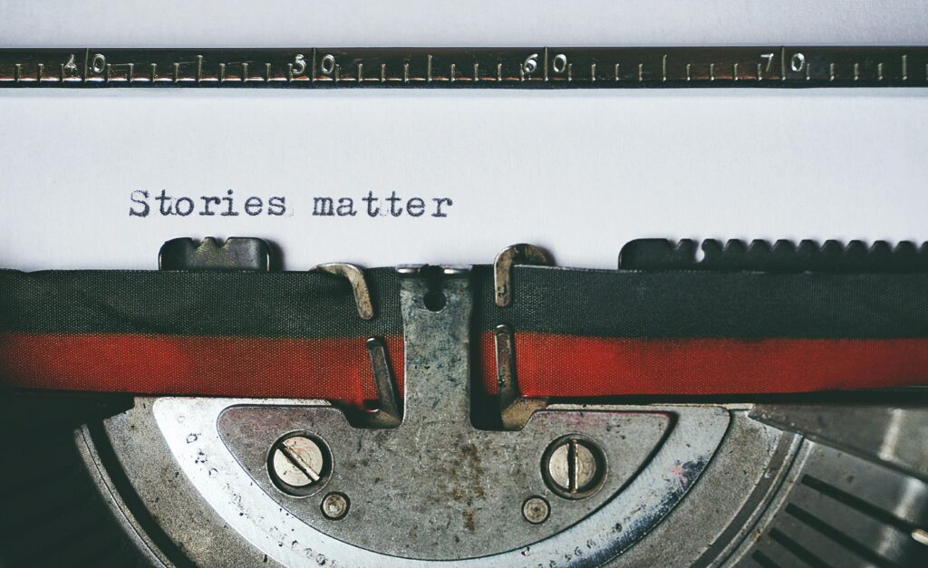 Close-up of a vintage typewriter with the text 'Stories matter' typed on paper, evoking nostalgia.